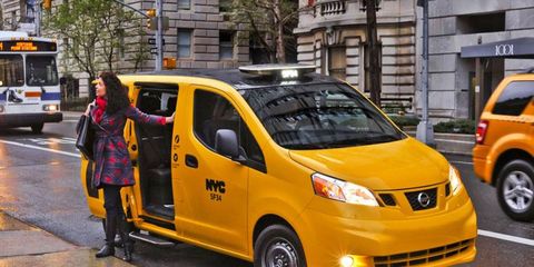 A passenger exits the 2014 Nissan NV200 taxi in New York City.