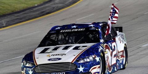 Brad Keselowski takes the American flag on a victory pass of the main grandstand on Saturday night at Kentucky Speedway.