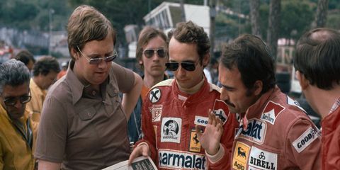 Author Alan Henry, left, shares some of his work with Niki Lauda and Clay Ragazzoni at Monte Carlo in 1976.