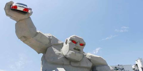 The newly constructed Monster Monument at Victory Plaza stands 46 feet tall and holds a full scale NASCAR COT car in his right hand.