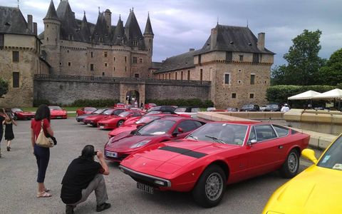 A Maserati Khamsin and McLaren MP4 12C in front of Chateau de Jumilhac.