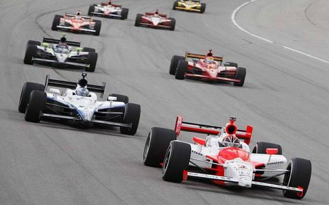 Helio Castroneves leads Marco Andretti, Justin Wilson and Helio Castroneves as he works his way up through the pack