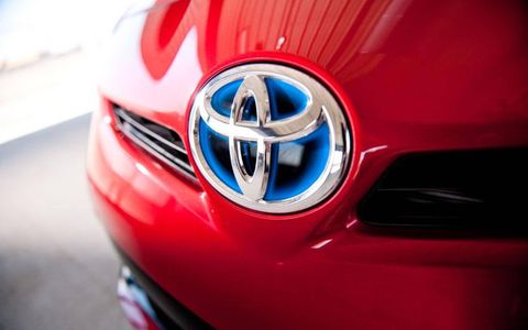 A close-up of the  2012 Toyota Prius Four hood emblem.