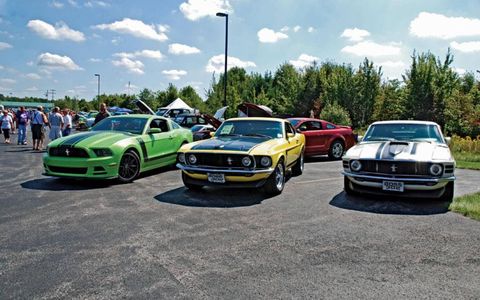 A collection of Boss 302's. From left to right, a 2013, 1969 and 1970 pose for photos.