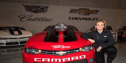 Erica Enders-Stevens poses with her Chevy Camero Pro Stock ride at the GM Heritage Center in Michigan.