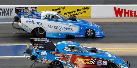 John Force, bottom, gets the jump on Tommy Johnson Jr. in the Funny Car finals in Charlotte on Sunday.