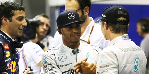 Singapore Grand Prix pole sitter Lewis Hamilton, center, is congratulated by teammate Nico Rosberg, right, and Daniel Ricciardo following qualifying on Saturday.