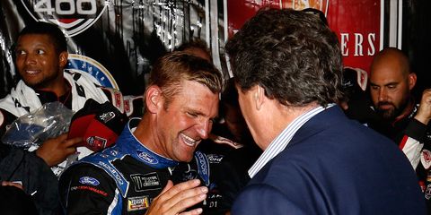 Clint Bowyer shakes hands with NASCAR vice chairman Mike Helton after winning the Monster Energy NASCAR Cup Series FireKeepers Casino 400.