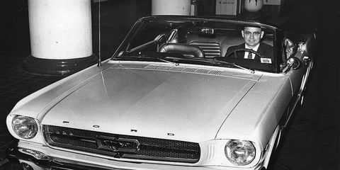 Arjay Miller sits behind the wheel of a Ford Mustang.
