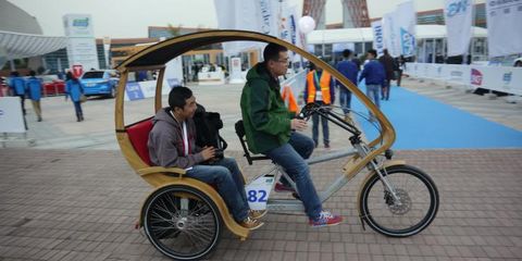 This tricycle pedi-cab features a bamboo roof and supplemental electrical power.