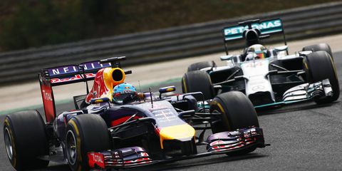 Red Bull's Sebastian Vettel, left, had his hands full trying to race with the likes of Mercedes' Lewis Hamilton this season. Vettel's boss says that the difference in horsepower has been too much to overcome.
