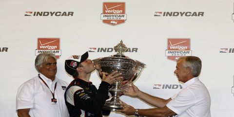 Will Power kisses the trophy after winning the IndyCar championship.