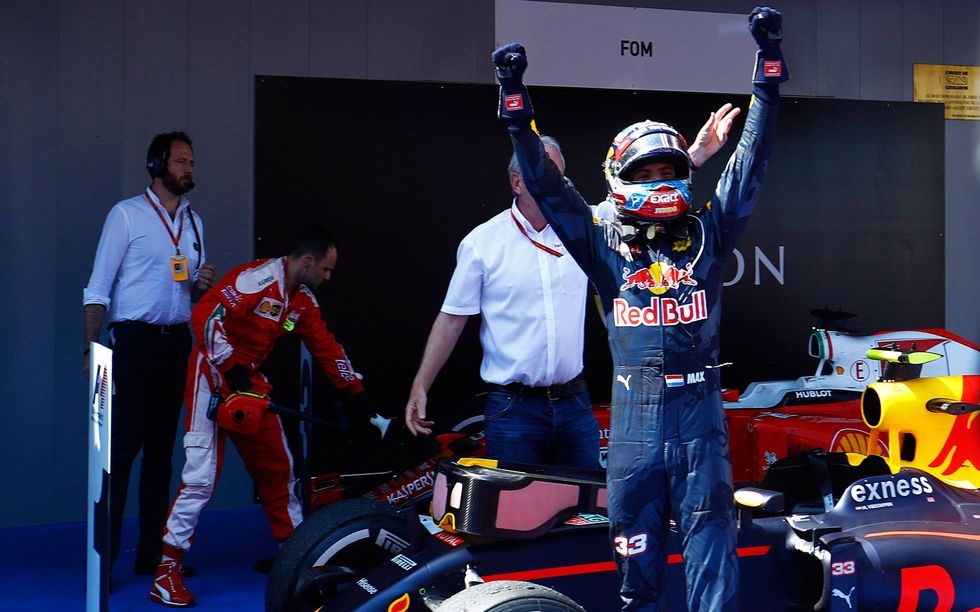 After climbing out of his car, Verstappen celebrates being the youngest driver to ever win a Formula 1 race.
