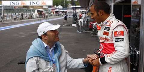 Philippe Streiff talks with Formula One champion Lewis Hamilton in 2009.