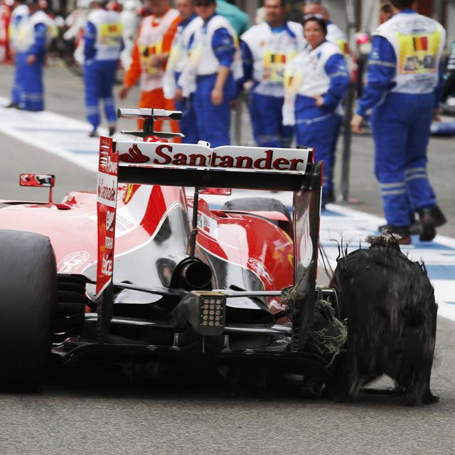 Sebastian Vettel's Ferrari limps into the pits after blowing a tire at Spa.