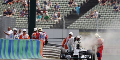 Lewis Hamilton climbs out of his smoking car on Saturday during Formula One qualifying. A fuel fire destroyed Hamilton's car, forcing his crew to rebuild. He, along with Kevin Maggnussen, will start from the pit lane.