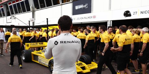 Jolyon Palmer stands with his Renault F1 team in the pit lane at Monaco.