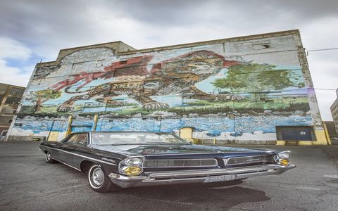 A '63 Pontiac Star Chief, aka Big Rhonda, sits in front of Kobie Solomon's "Detroit Chimera" mural at Russell Industrial.