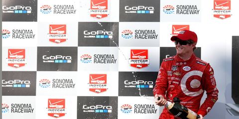 Scott Dixon unleashes champagne after winning in Sonoma.