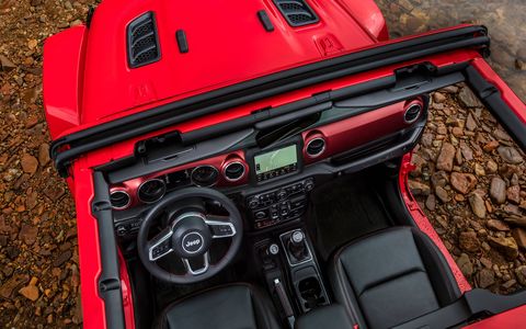 As with the rest of the off-roader, the interior of the 2018 Jeep Wrangler JL gets a big upgrade. A two-door Wrangler Rubicon (identifiable by the red painted dashboard insert) and a four-door Sahara are shown here.
