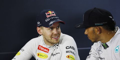 Defending Formula One series champion Sebastian Vettel, left, shares a word with current points leader Lewis Hamilton after Sunday's Formula One Singapore Grand Prix.