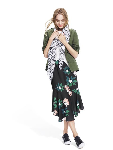 white tee with olive utility jacket and black floral fluted skirt