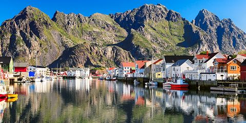 Body of water, Mountain, Reflection, Mountainous landforms, Water transportation, Fjord, Town, Mountain range, Boat, Harbor, 