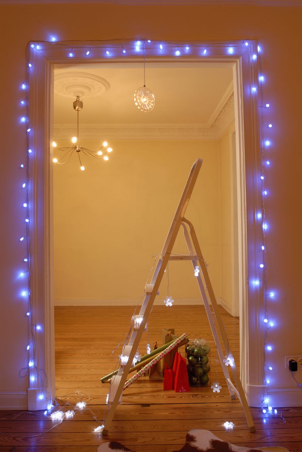 Aiutati con una scala e fai scorrere lungo gli stipiti delle porte le luci di Natale