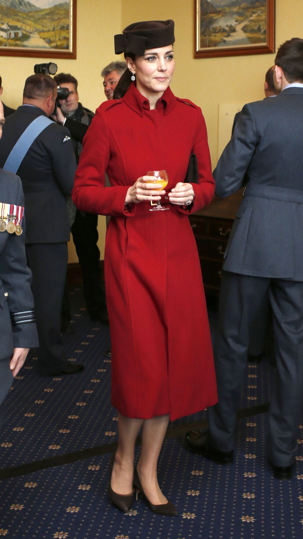 <p>La duchessa indossa un cappotto rosso di L.K. Bennett con un cappellino con fiocco e scarpe in terra bruciata alla cerimonia della Royal Air Force Valley</p>