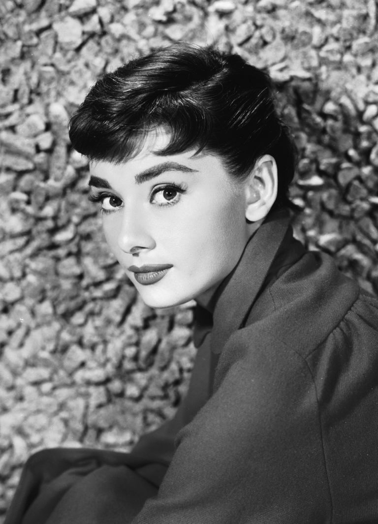 Portrait of Belgian-born American actress Audrey Hepburn (1929 - 1993) as she sits by a stone wall, early 1950s. (Photo by Hulton Archive/Getty Images)
