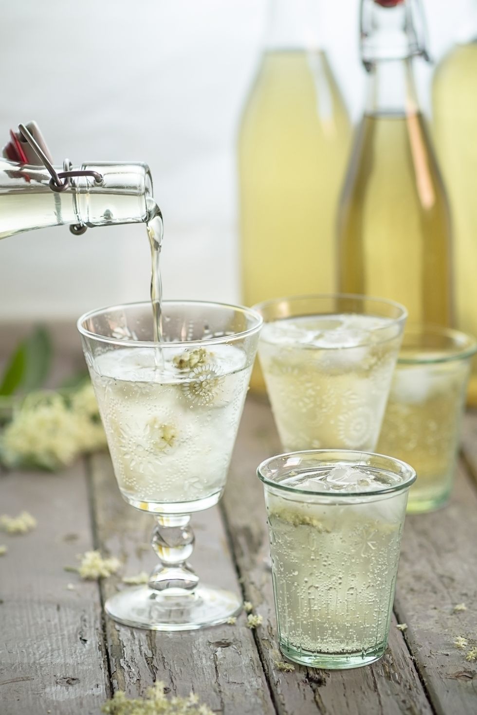 Pouring elderflower cordial into drinking glas