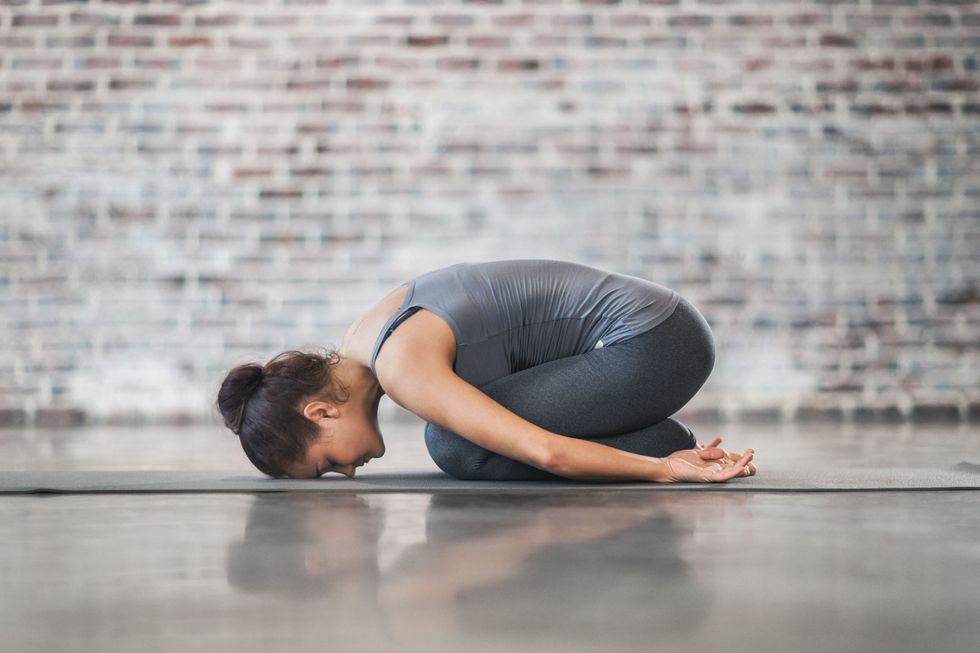 Young Woman Doing Yoga Meditation and Stretching Exercises. Stock photo.