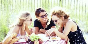 tre ragazze sorridono a pranzo al ristorante mangiando cibo sano