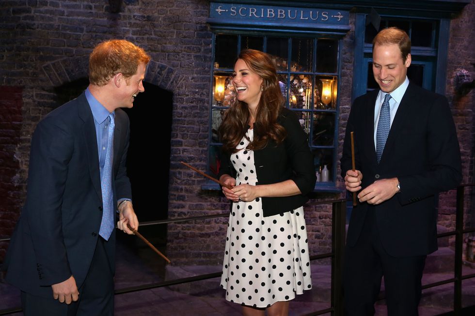 LONDON, ENGLAND - APRIL 26:  Prince Harry, Catherine, Duchess of Cambridge and Prince William, Duke of Cambridge laugh as they hold wands on the set used to depict Diagon Alley in the Harry Potter Films  during the Inauguration Of Warner Bros. Studios Leavesden on April 26, 2013 in London, England.  (Photo by Chris Jackson - WPA Pool/Getty Images)