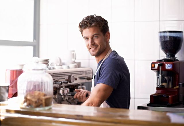 a good looking barista man working at the cafe