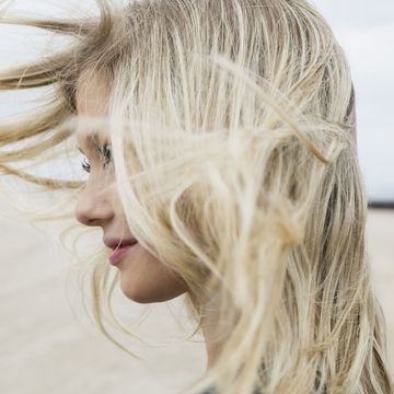 海辺で美髪をなびかせる女性
