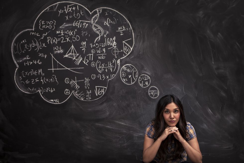 黒板の前に座る数学者の女性