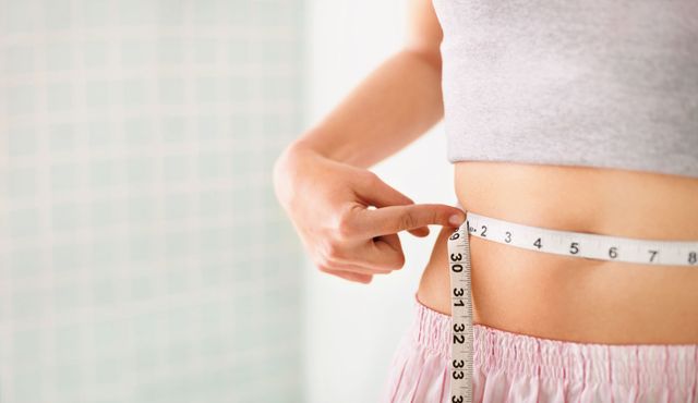 ダイエット／お腹周りをメジャーで測る女性