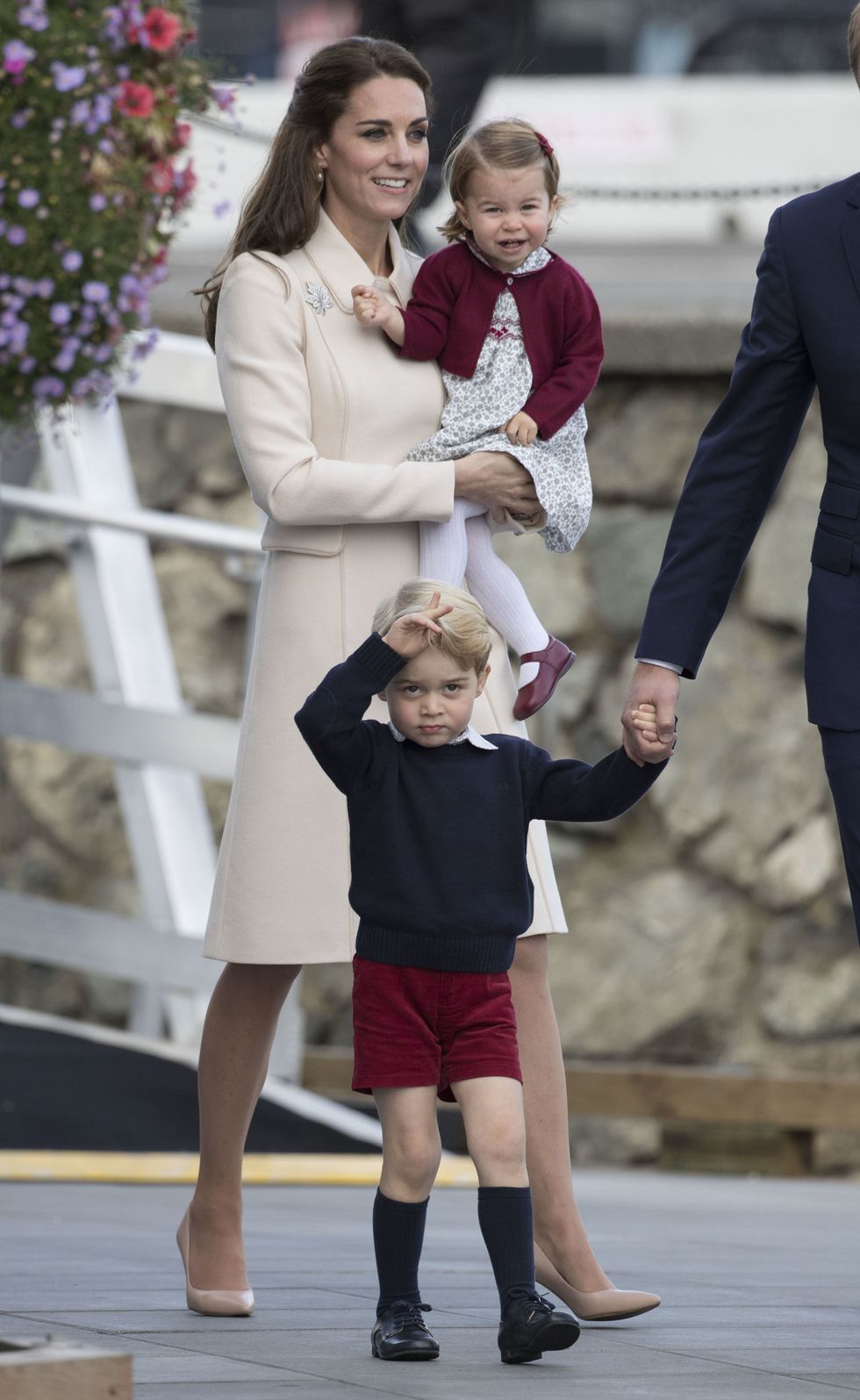 <p>また別のチルドレンズパーティでは、子ども達はカナダを象徴するメープルになぞらえた"メープルローズ"と呼ばれる赤でお揃いに。なんだかご機嫌そうなシャーロット王女と、緊張気味のジョージ王子の後ろで、2人をあたたかく見守るキャサリン妃はまたもオフホワイトコーデ。スッキリとしたデザインながら、端々のディテールが丸み帯びたコートが、無駄のない上品さを演出。さらに胸元にはメープルリーフ型のブローチをさりげなく添えて、お呼ばれコーデとしても隙がない完成度に！</p>