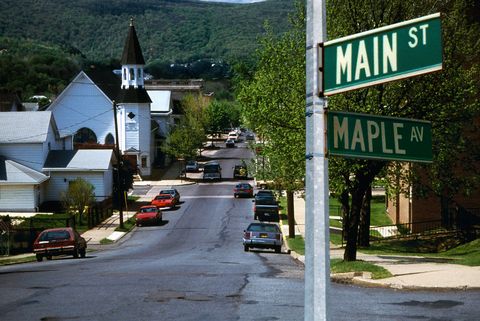 Motor vehicle, Road, Automotive exterior, Road surface, Town, Thoroughfare, Signage, Street sign, Sign, House, 