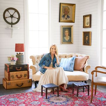 sheryl crow's living room with oil paintings and stack of vintage suitcases