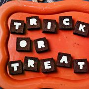 small square cake sandwiches with letters printed on each one spelling trick or treat