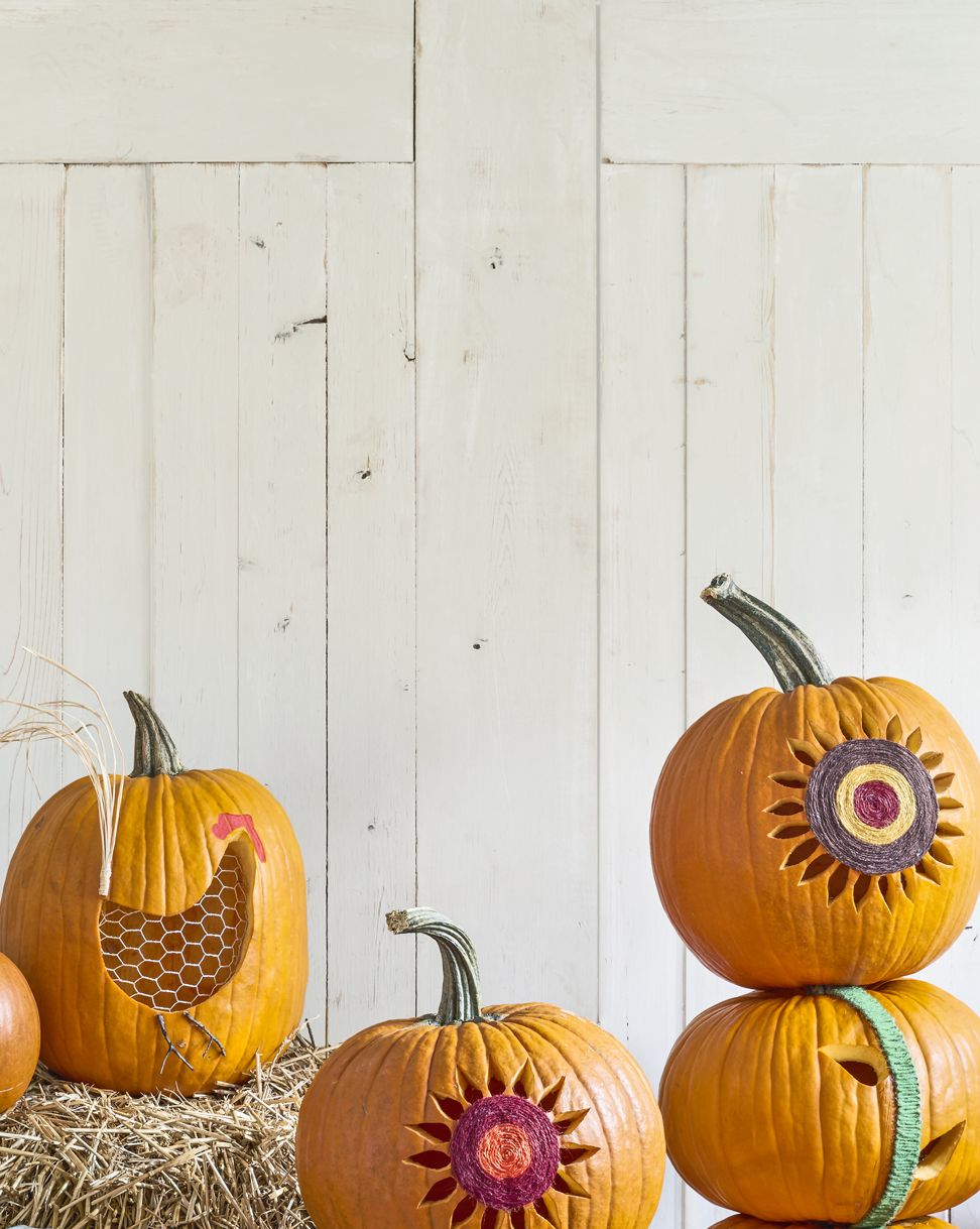 stacked pumpkins carved and decorated to resemble sunflowers