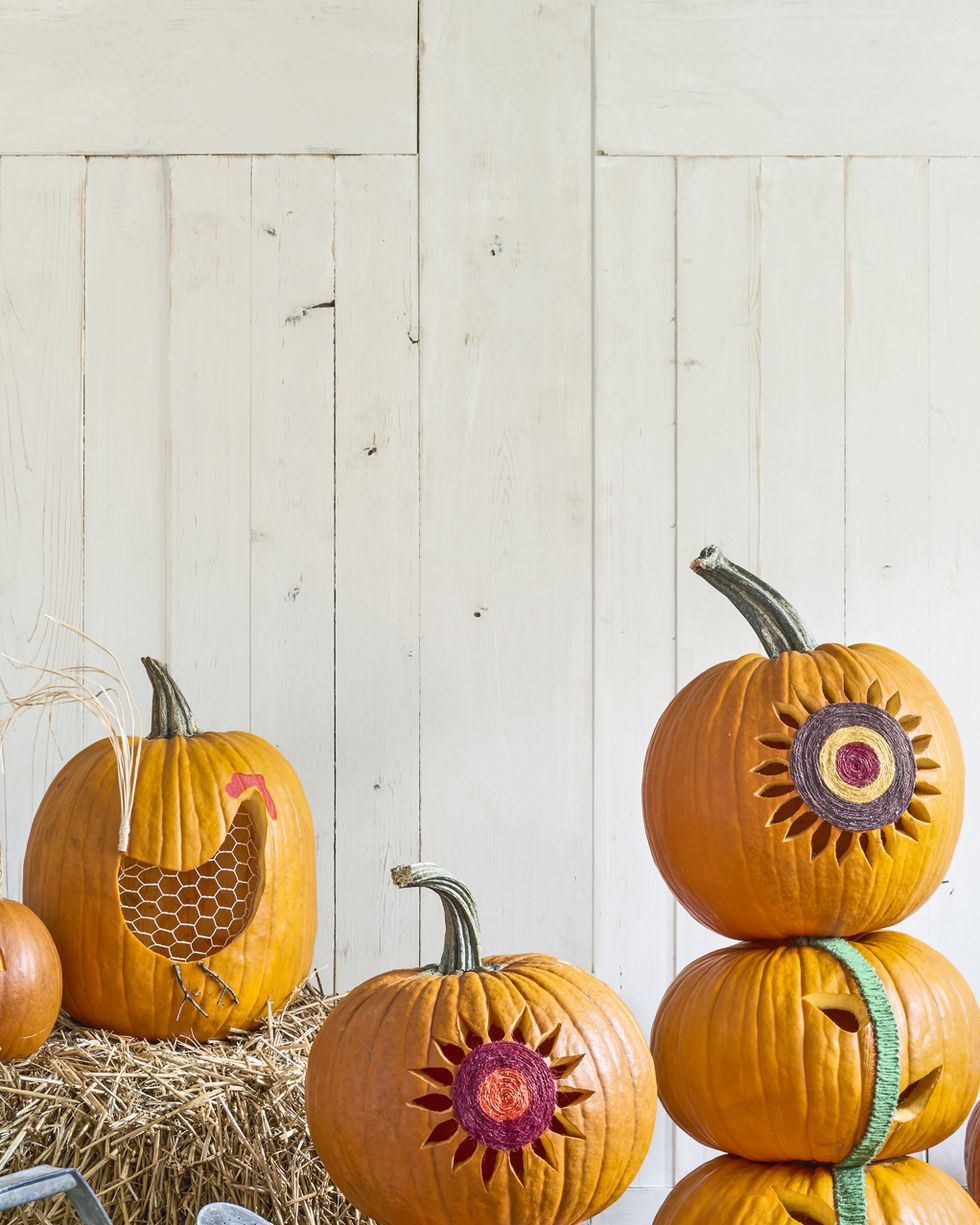stacked pumpkins carved and decorated to resemble sunflowers