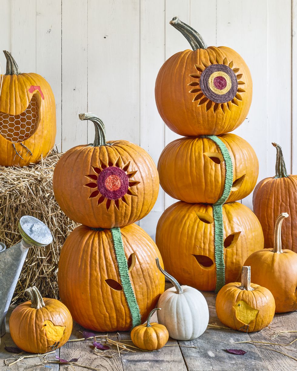 stacked pumpkins carved and decorated to resemble sunflowers