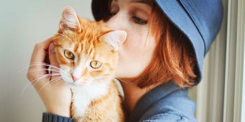 Woman kissing orange cat