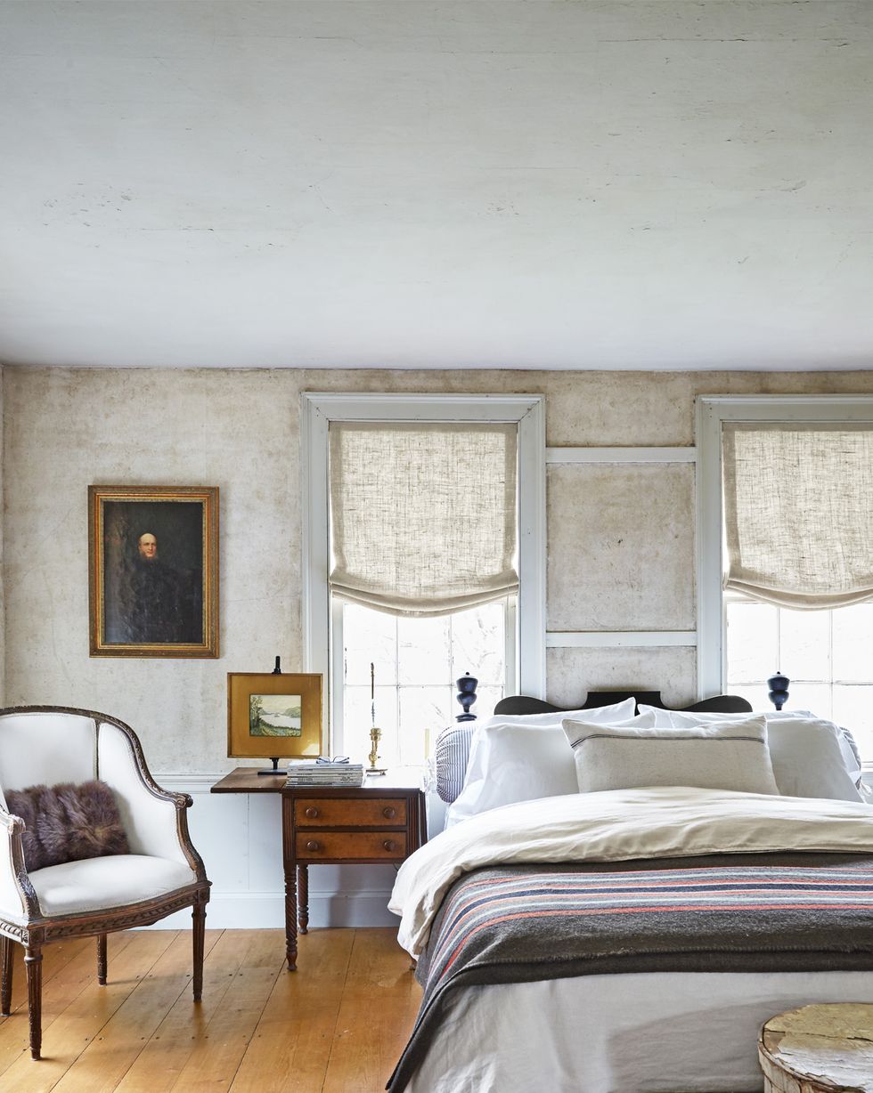 linen roman shades hang in a neutral bedroom