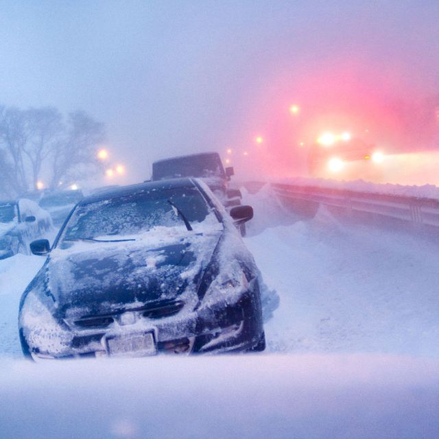 cars stuck on highway in winter snowstorm.