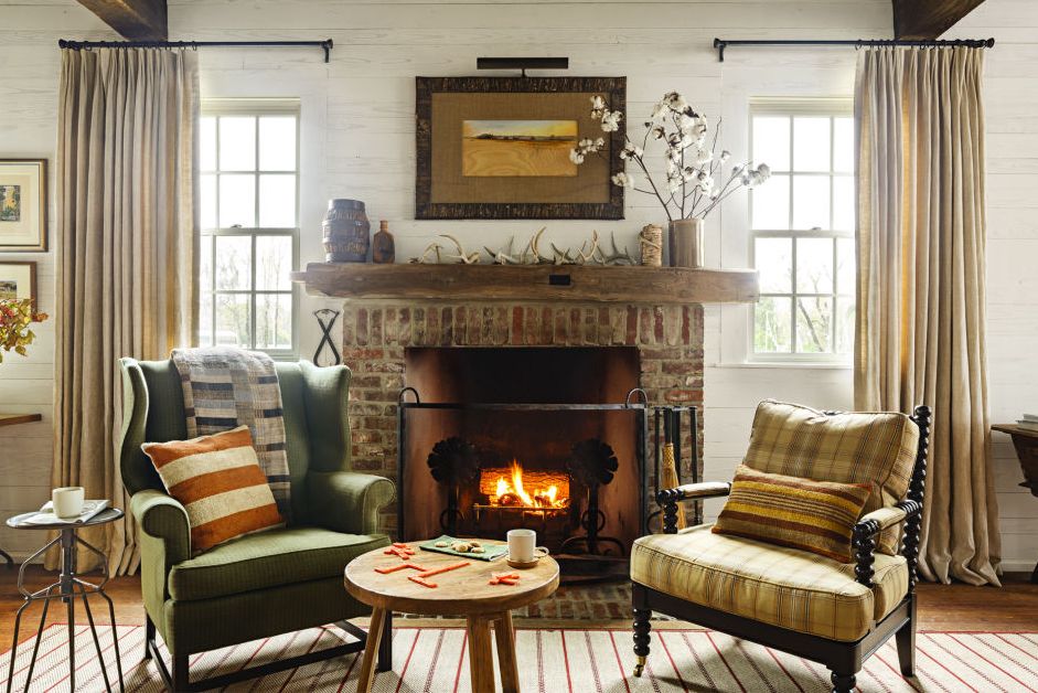 a pair of chairs in a cozy living room with a fire