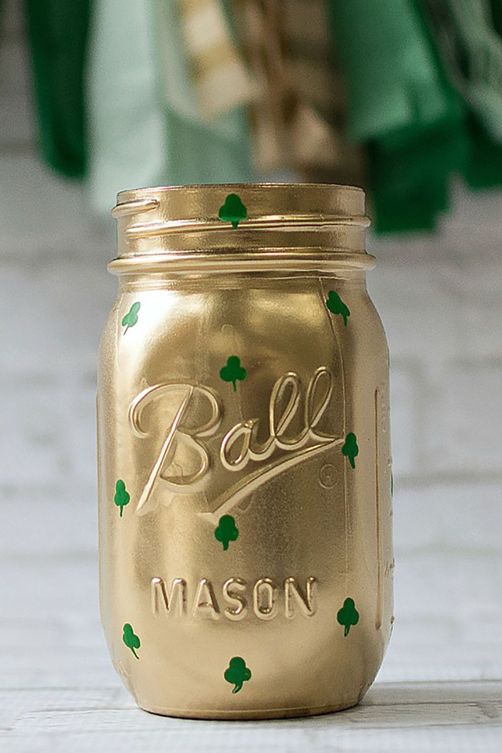 mason jar craft painted gold, decorated with tiny green painted shamrocks, st patrick's day craft for adults